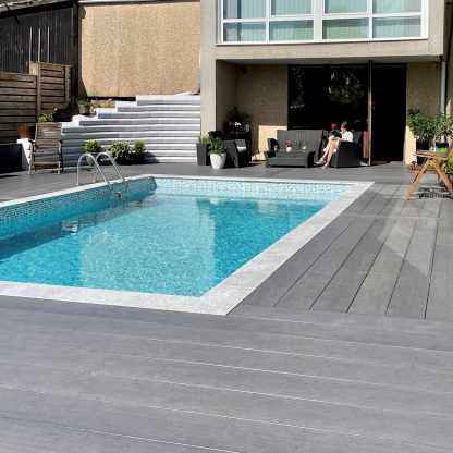 grå komposittrall runt en pool på snygg villa